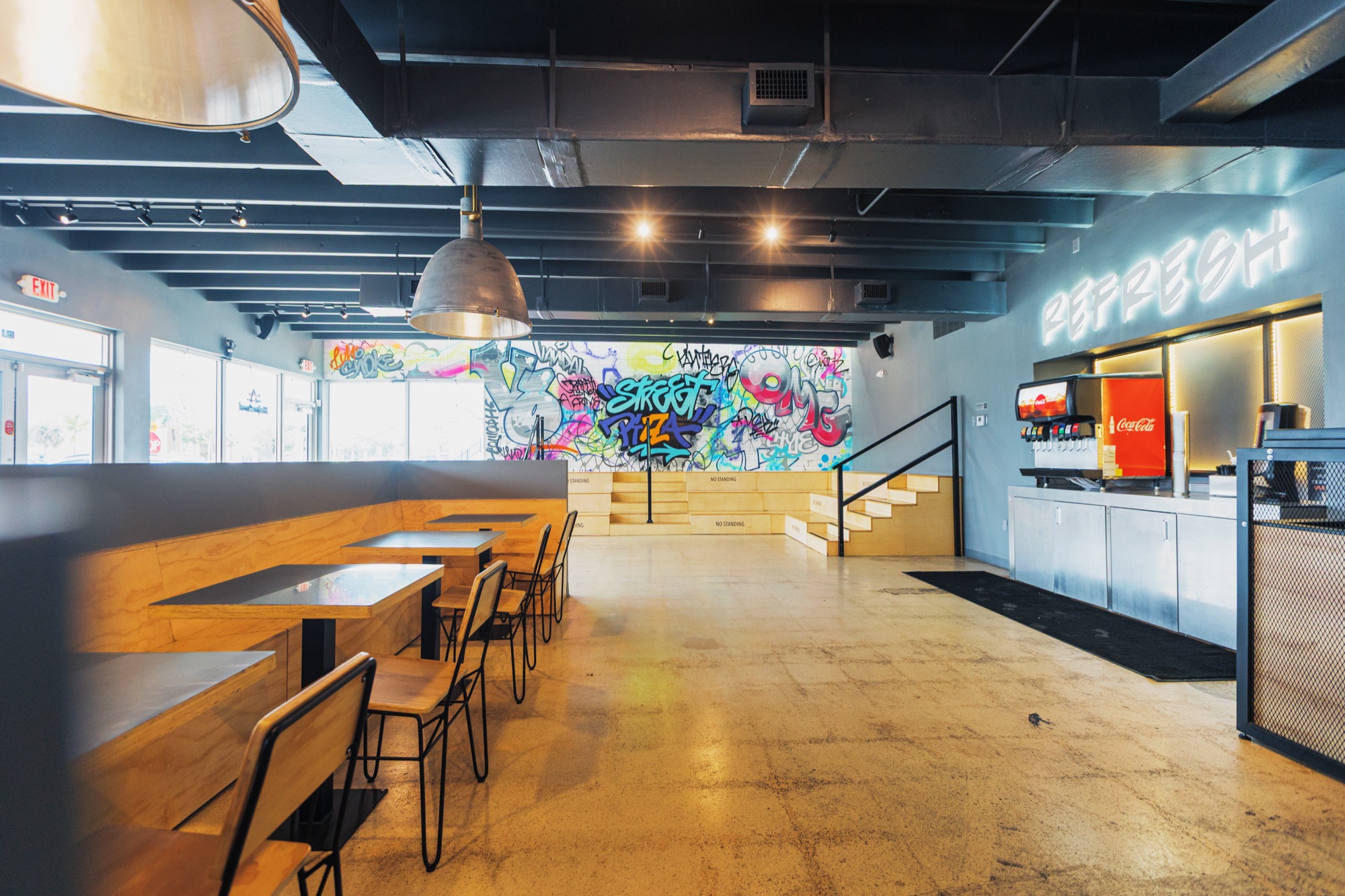 Golden Lizzard's Miami dining room with colorful graffiti murals and wooden seating